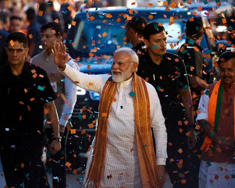 Prime Minister Narendra Modi greets supporters at BJP headquarters in New Delhi after the party's state election wins
