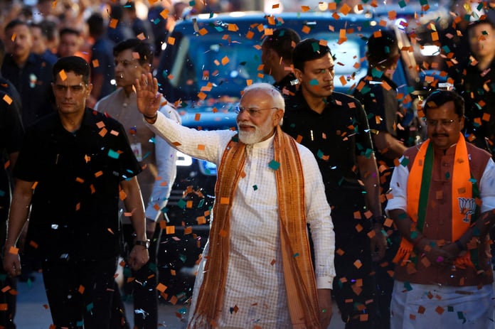 Prime Minister Narendra Modi greets supporters at BJP headquarters in New Delhi after the party's state election wins