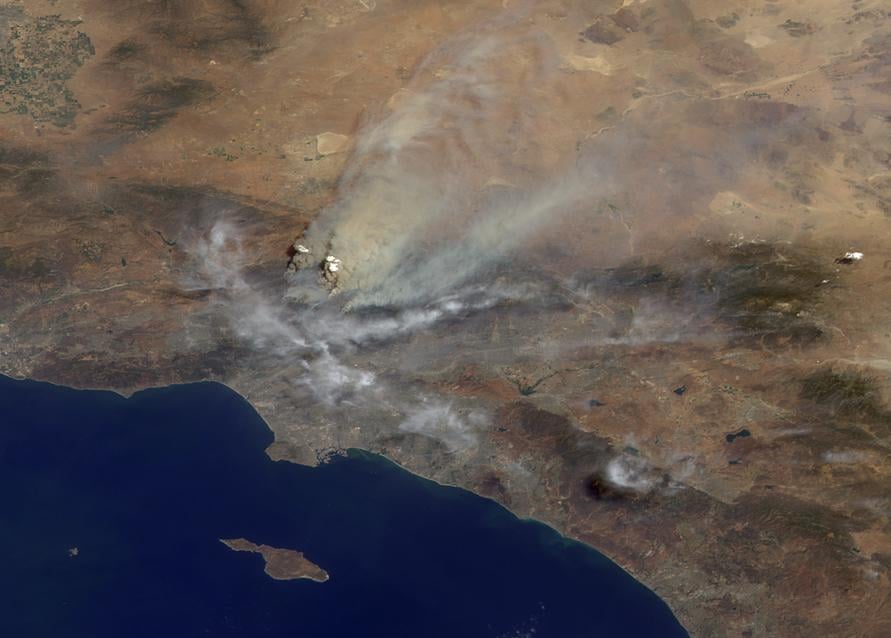 A NASA satellite view of thick wildfire smoke blanketing Southern California, the kind of Western fire season researchers study