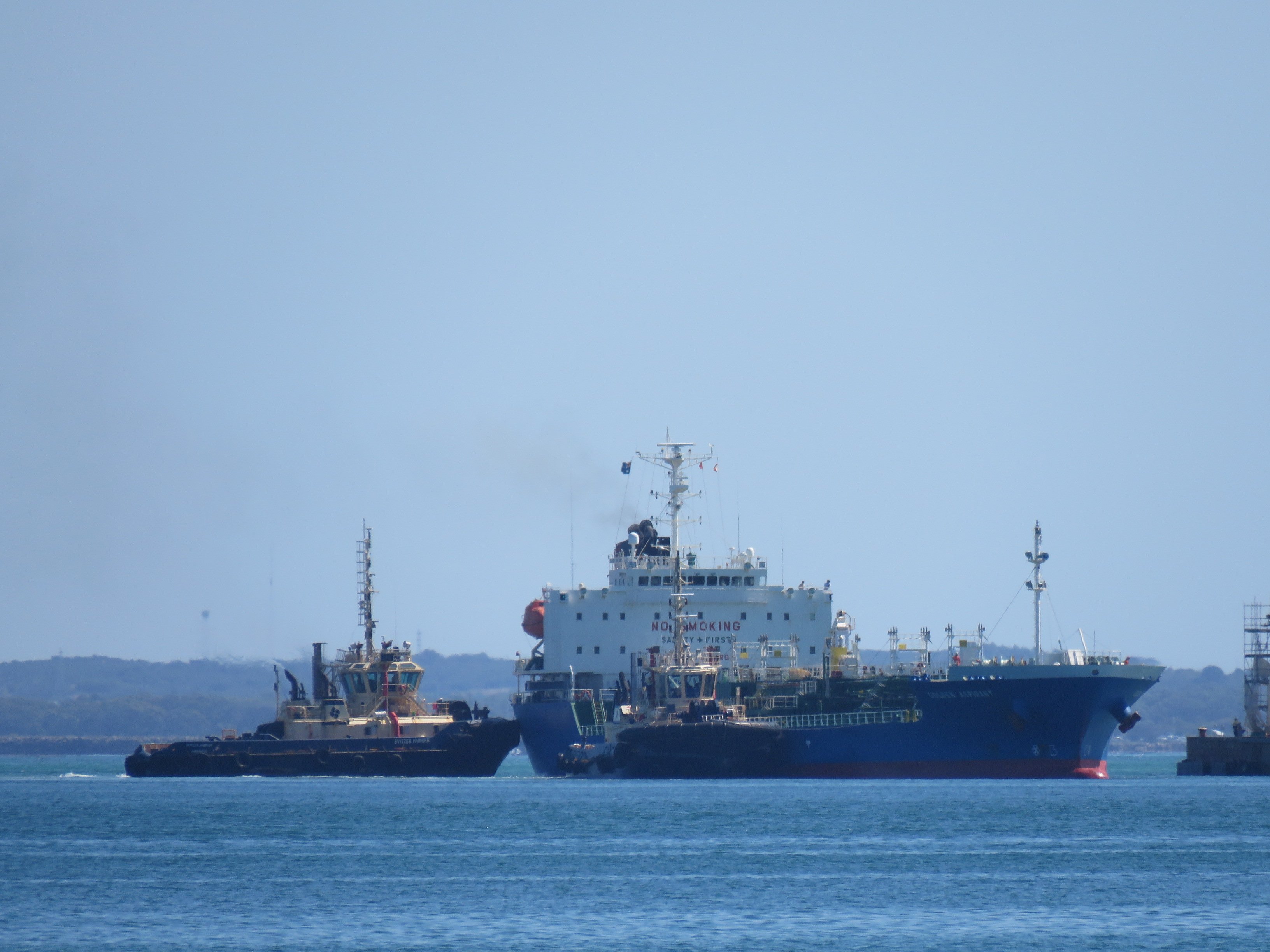 Oil and chemical tanker moored at a refinery jetty, illustrating the crude shipments repriced by the US-Iran exchange near Hormuz