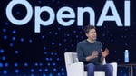 OpenAI chief executive Sam Altman seated on stage in front of a large OpenAI logo