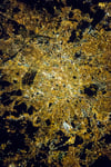 NASA astronaut photograph of Paris at night showing the Seine River as a thin black line with the bright Avenue des Champs Elysees and the radial street pattern around the Arc de Triomphe