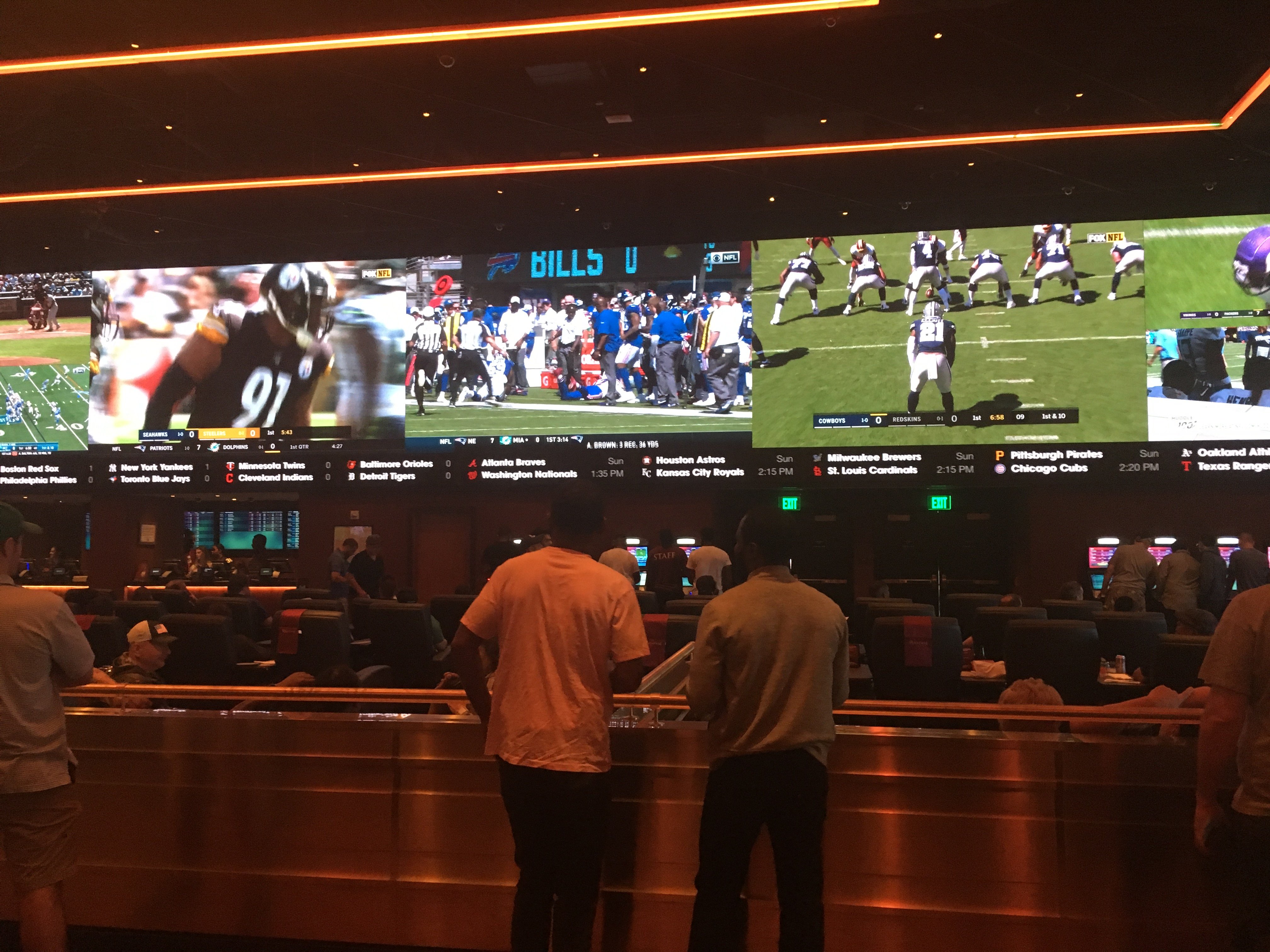Crowded Parx Casino sportsbook with screens showing NFL games and active sports betting windows