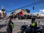 Police gather in front of a collapsed building after a magnitude 7.8 earthquake in General Santos, Philippines