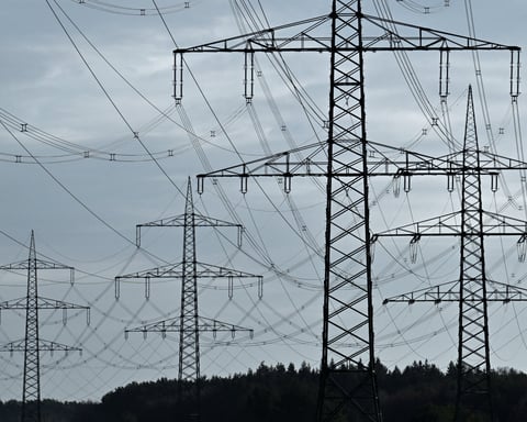High-voltage power lines and electricity pylons near the A24 motorway in Germany, illustrating the COP31 electrification target
