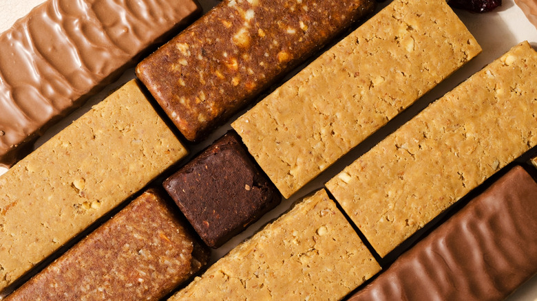Various protein bars lined up on a table for nutritional ingredient review