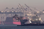 Pollution rises from a ship cruising past the Port of Long Beach in San Pedro, California, where tankers and container ships enter and exit