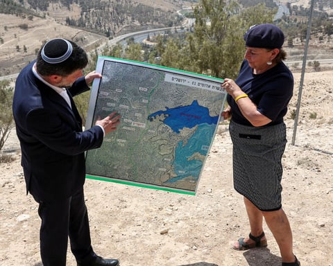 Israeli Finance Minister Bezalel Smotrich holds map of E1 settlement scheme near Maale Adumim in occupied West Bank