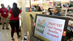 A SNAP and EBT food stamp benefits accepted sign in a store