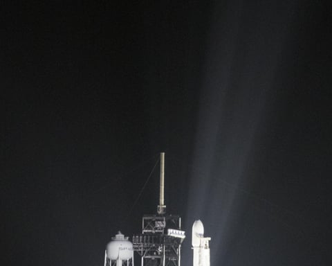 A SpaceX Falcon Heavy rocket lifts off at night from Kennedy Space Center