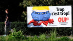 A Swiss People's Party campaign poster reading Enough is enough on a street in Lausanne