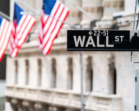 Wall Street street sign with American flags, as prediction exchange Kalshi rolls out employment verification to fight insider trading