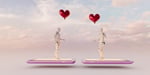 Two humanoid robots holding heart-shaped balloons, illustrating AI-powered dating