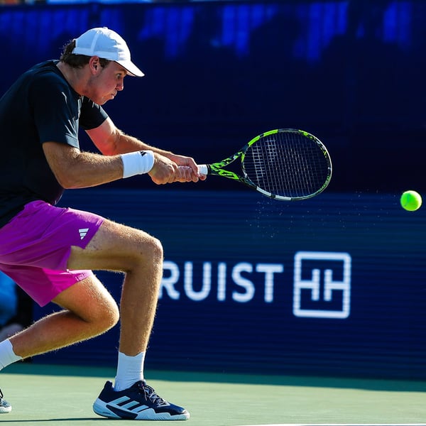 Alex Michelsen hits a backhand during an ATP Tour hard court match