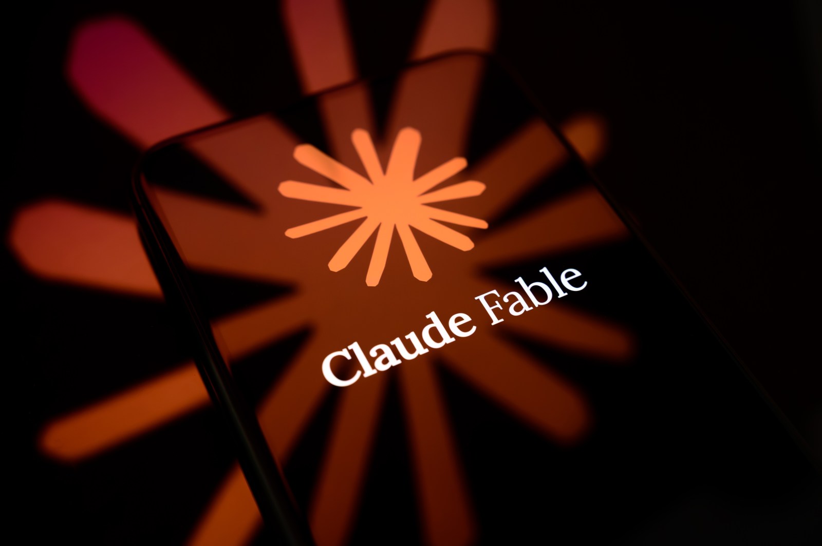 The Claude logo displayed on a smartphone screen in a photo illustration