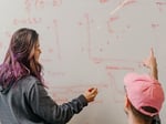 Anthropic team members collaborating at a whiteboard in the AI company's office, whose $5 billion stake anchors the Situational Awareness fund