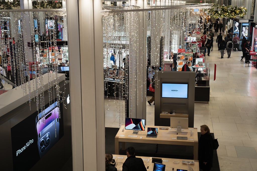 Apple product display showing iPhone and Mac devices in a retail setting
