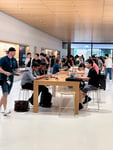 Customers using Apple devices inside an Apple retail store