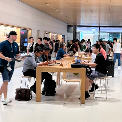 Customers using Apple devices inside an Apple retail store