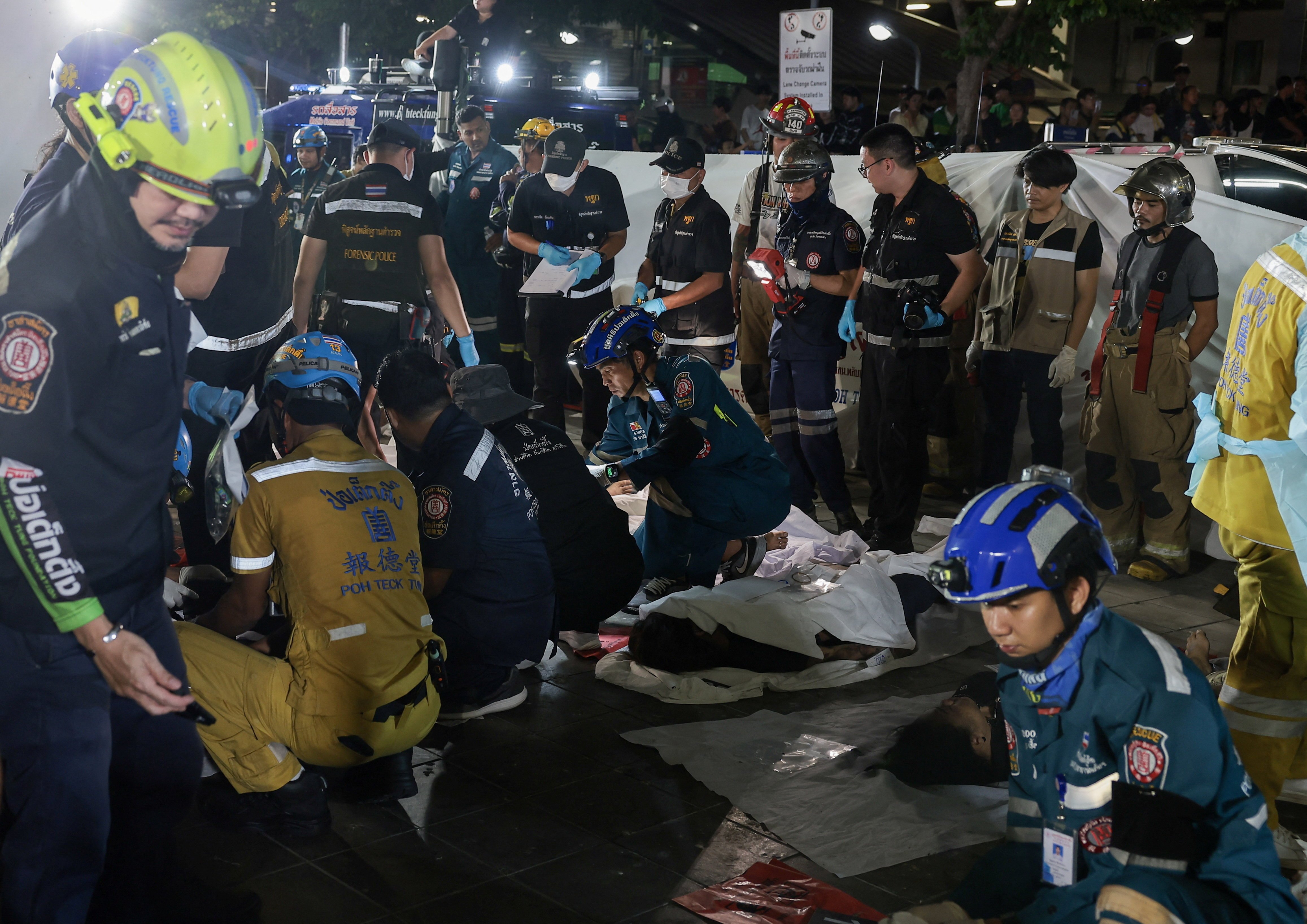 Emergency personnel and firefighters at the scene of the Na Ladprao pub fire in Bangkok that killed 27 people on July 13 2026