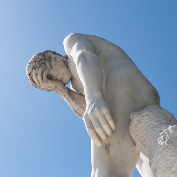 Statue with head in hands symbolizing big tech accountability under EU Digital Markets Act as Google rivals seek damages