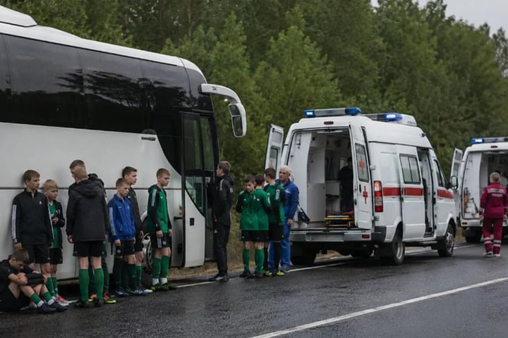 Belarusian youth football team players stand beside their bus with emergency services after drone strike in Bryansk region Russia June 2026