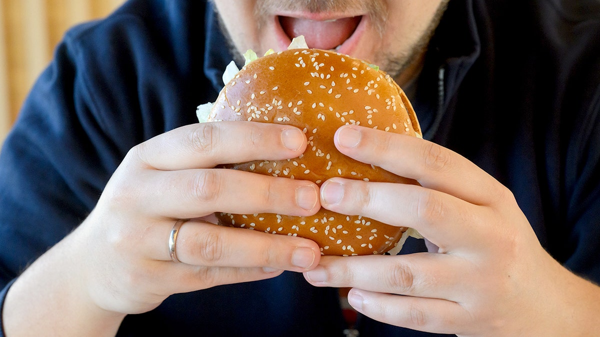 A customer eating a Burger King Whopper burger July 2026