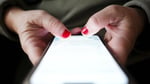 A person's hands typing on a smartphone, illustrating the Canadian wireless fee dispute