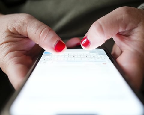A person's hands typing on a smartphone, illustrating the Canadian wireless fee dispute
