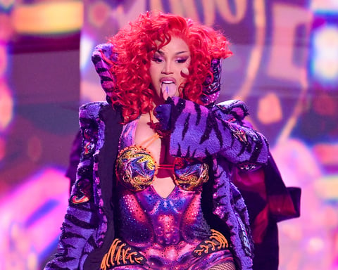 Cardi B performing at the 2026 BET Awards in a colorful bodysuit with fiery red hair