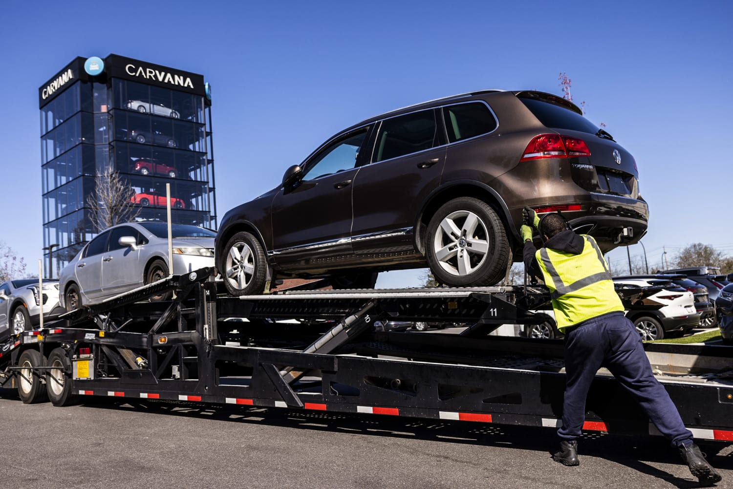 Worker loads vehicles onto transporter at Carvana vending machine Uniondale New York