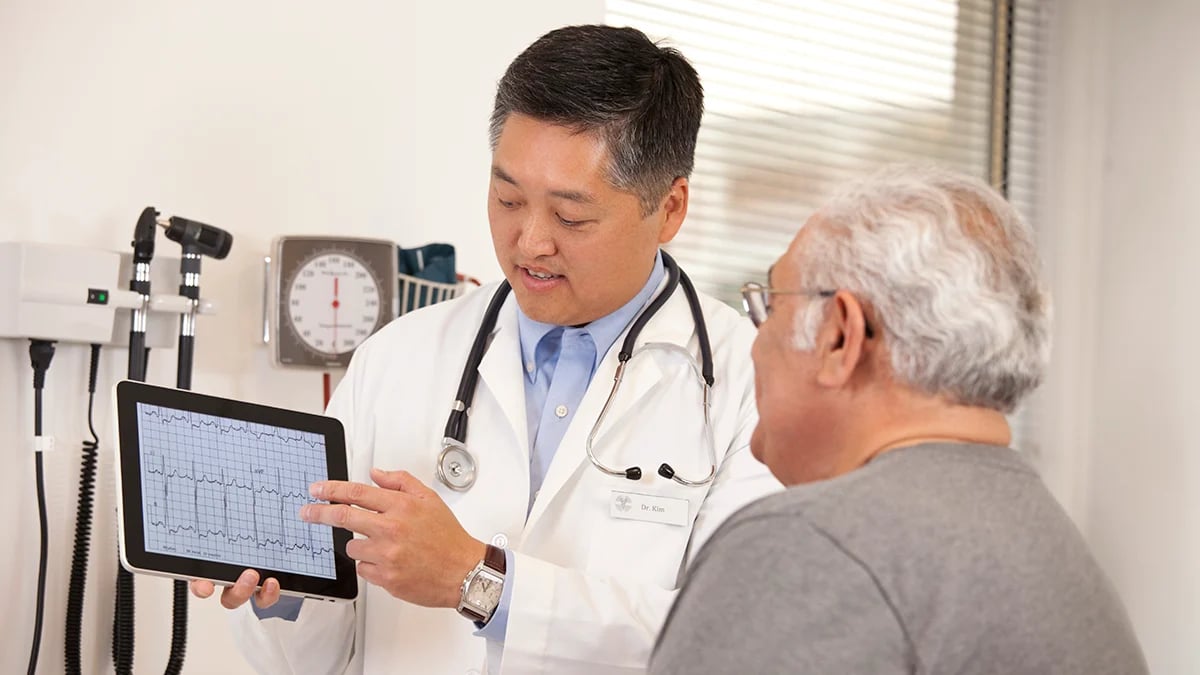 A pharmacist consulting a patient about heart medication including statins for cardiovascular disease prevention