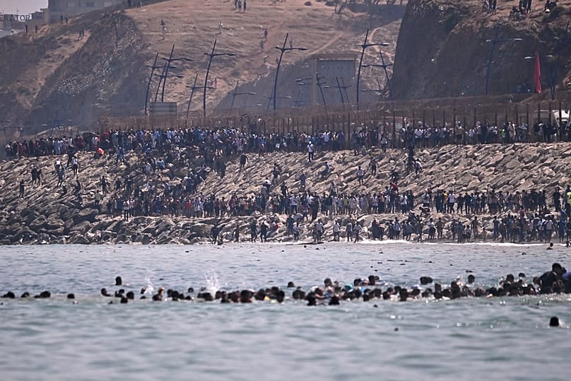 Migrants crossing from Morocco into Spain's Ceuta enclave on July 30, 2026