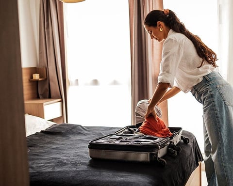 A traveler packing a suitcase before a Chicago hotel stay during the 2026 bedbug season surge