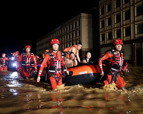 Rescue workers evacuate residents by boat after dam breach floods Nanning, Guangxi, China, during Tropical Storm Maysak, July 2026.