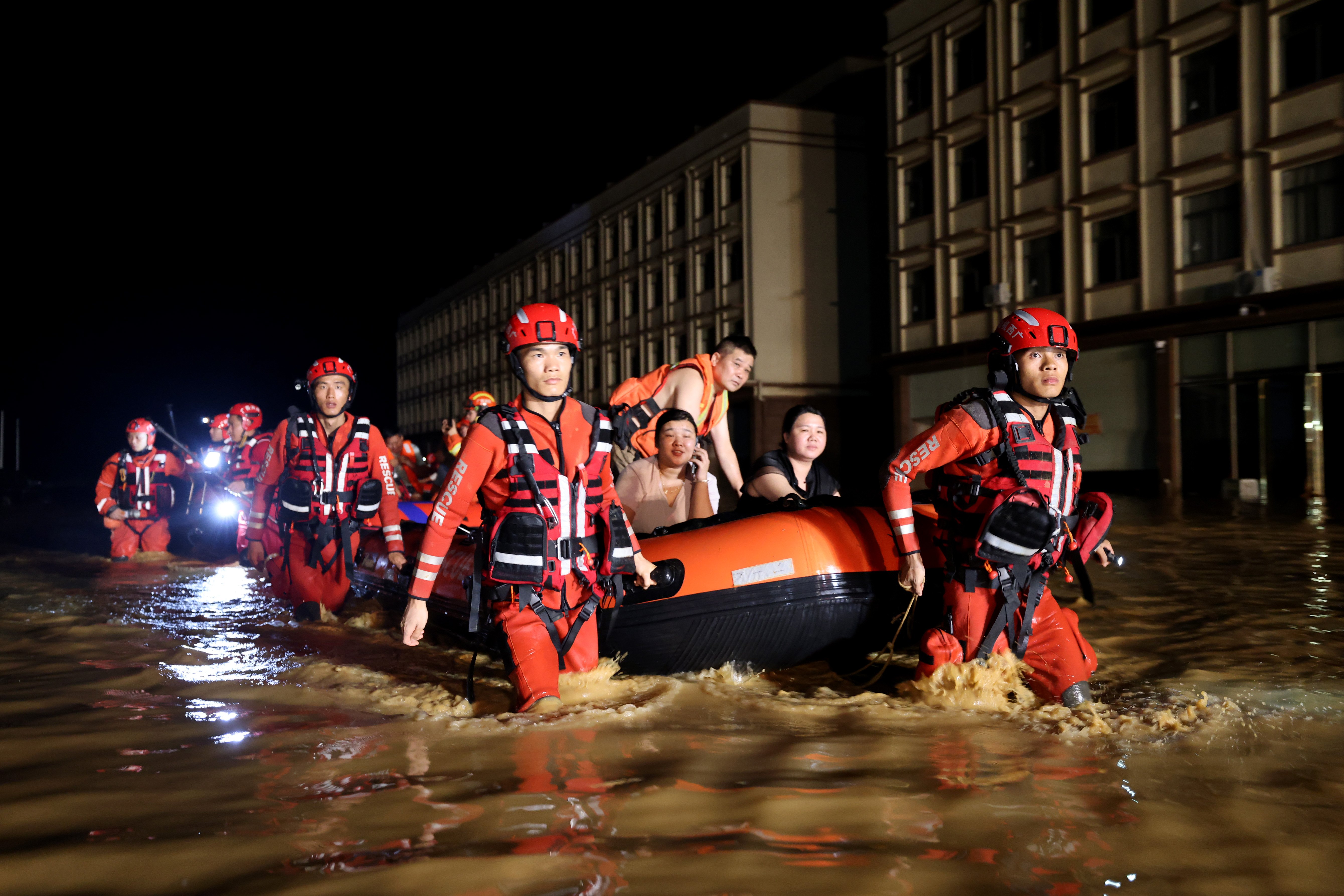 Rescue workers evacuate residents by boat after dam breach floods Nanning, Guangxi, China, during Tropical Storm Maysak, July 2026.