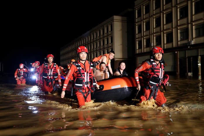 Rescue workers evacuate residents by boat after dam breach floods Nanning, Guangxi, China, during Tropical Storm Maysak, July 2026.