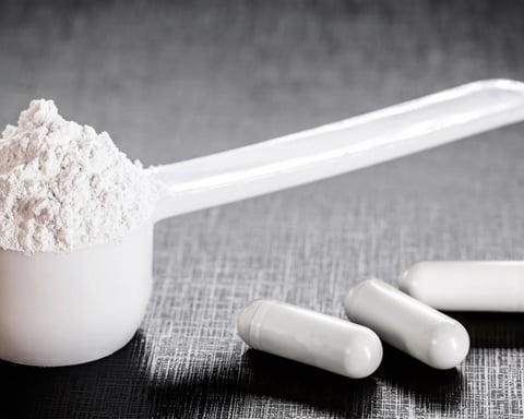Creatine supplement powder in a container, long used by athletes and now studied for depression