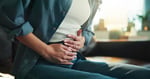 Person suffering from stomach pain caused by cyclosporiasis parasite infection