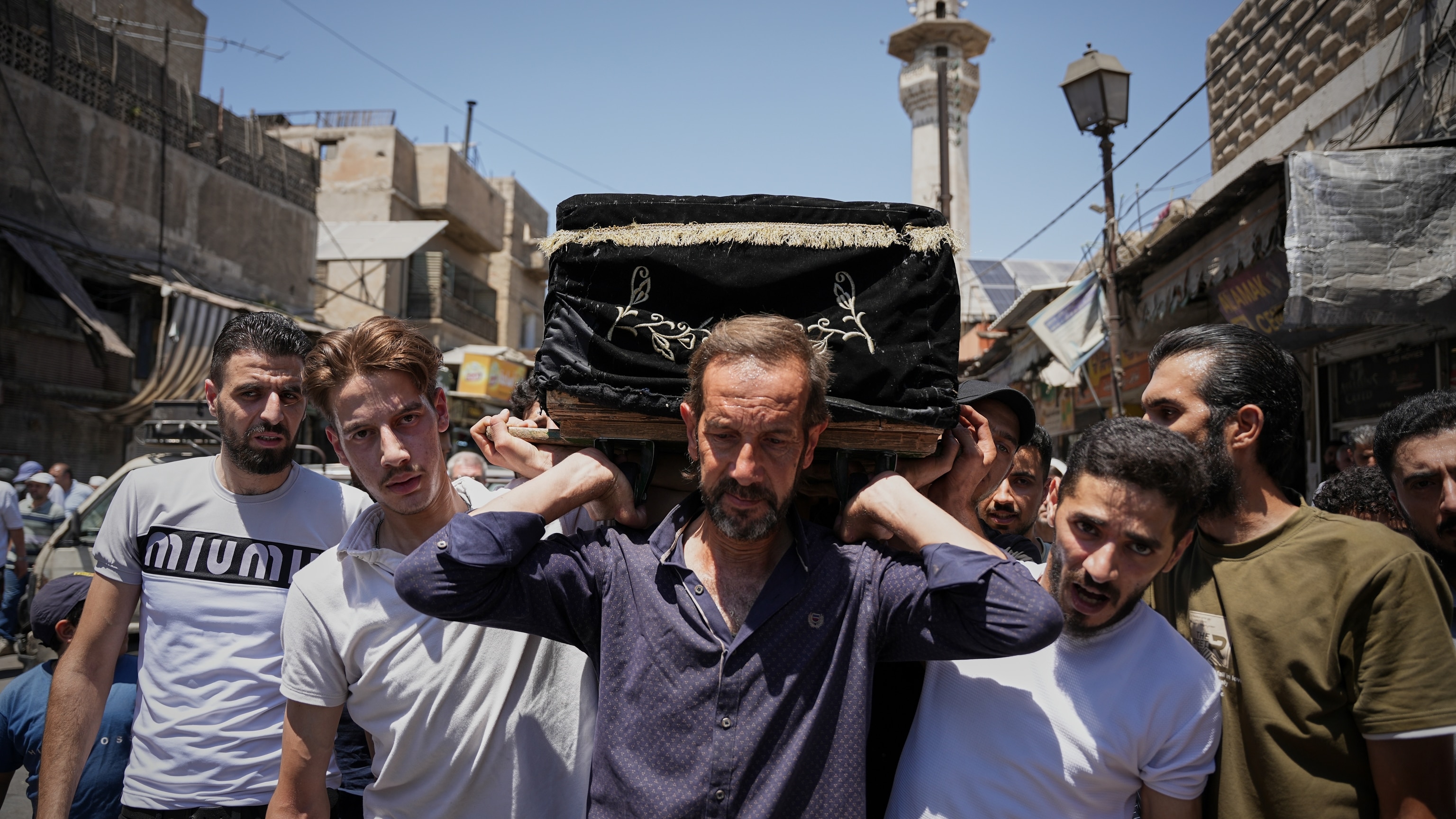 Mourners carry the coffin of Fathi Muhammad Saeed Qabbani in Al-Midan Damascus July 3 2026 after Damascus cafe bombing