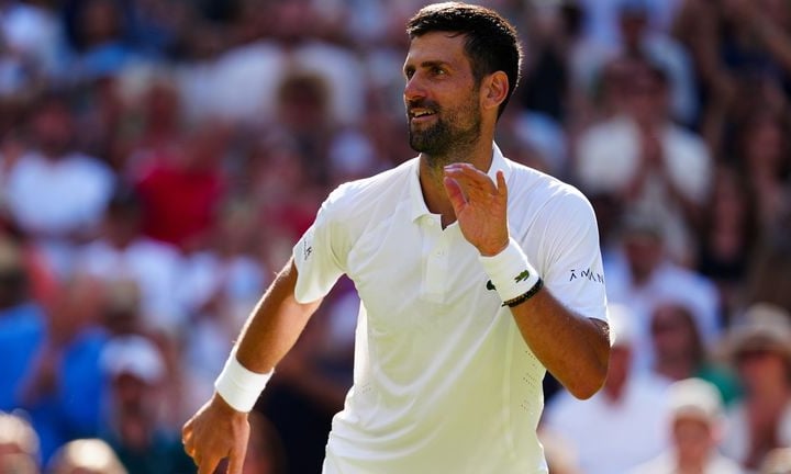 Novak Djokovic on Centre Court at Wimbledon 2026, celebrating after equaling Roger Federer's all-time record of 105 men's wins