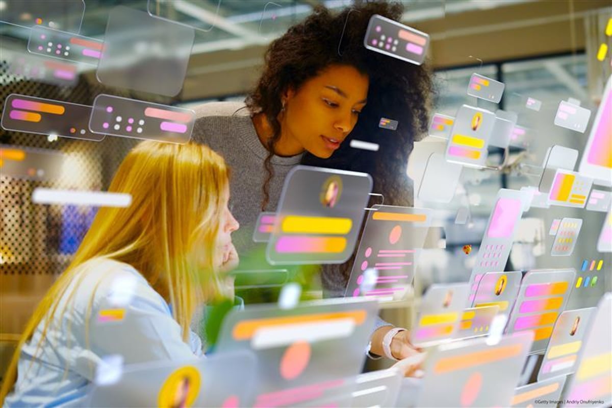 Young professionals working in a modern office surrounded by multicolored digital data screens illustrating AI systems in European institutions