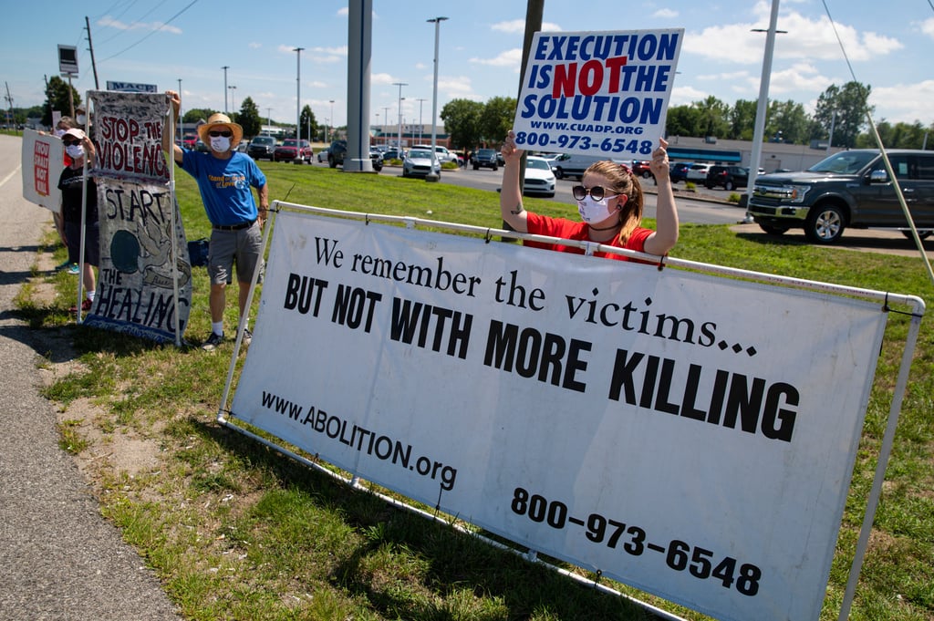 A protester holds a sign against the death penalty outside a federal prison in Terre Haute, Indiana