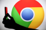 Person holding a phone displaying the Google Chrome logo, representing AI-powered security patching in 2026