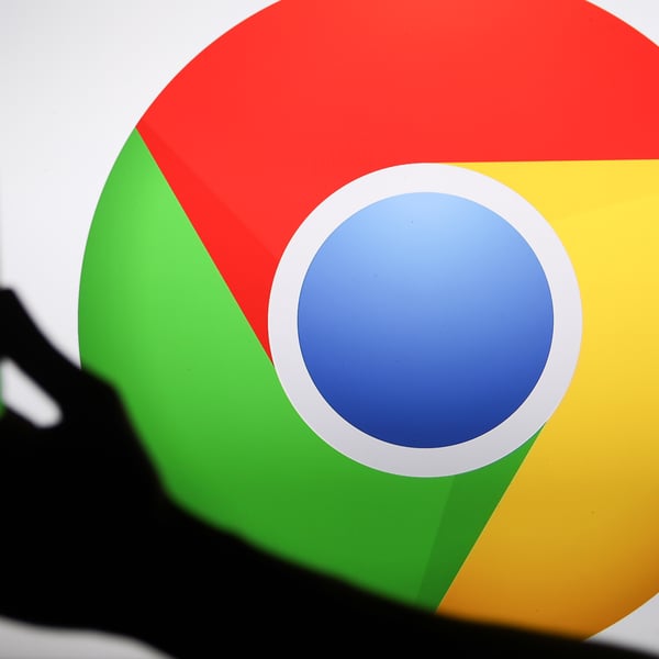 Person holding a phone displaying the Google Chrome logo, representing AI-powered security patching in 2026