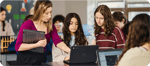 Students collaborate on Google Chromebooks in a school classroom setting
