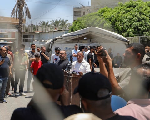 Hamas spokesman Ismail al-Thawabta at podium announcing Emergency Committee dissolution in Gaza City