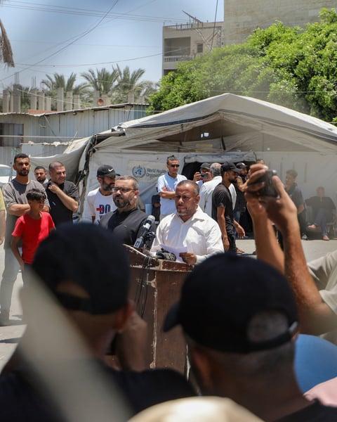 Hamas spokesman Ismail al-Thawabta at podium announcing Emergency Committee dissolution in Gaza City