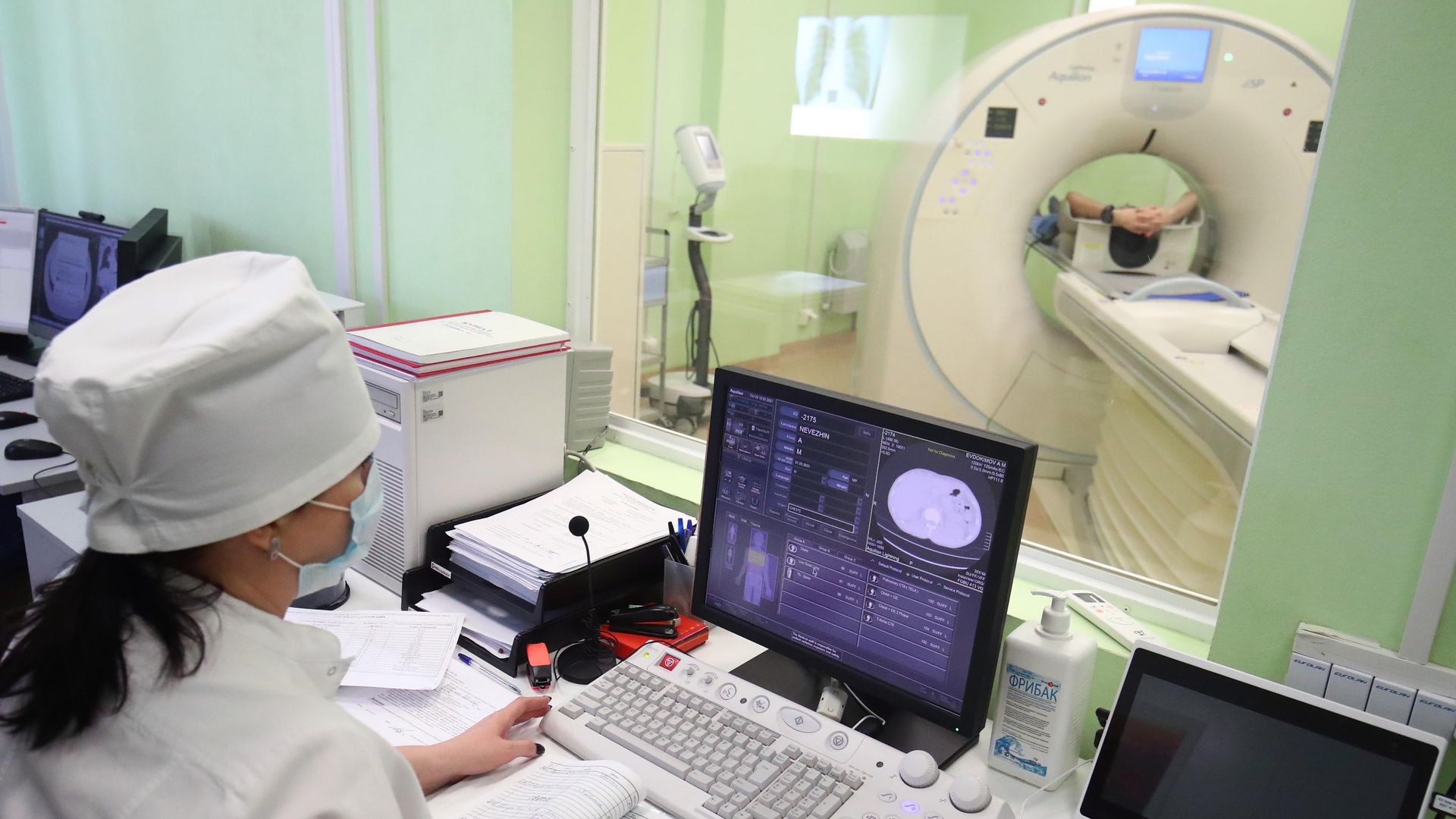 Radiology technician performing CT scan in hospital as hedge funds push healthcare bets to five year high