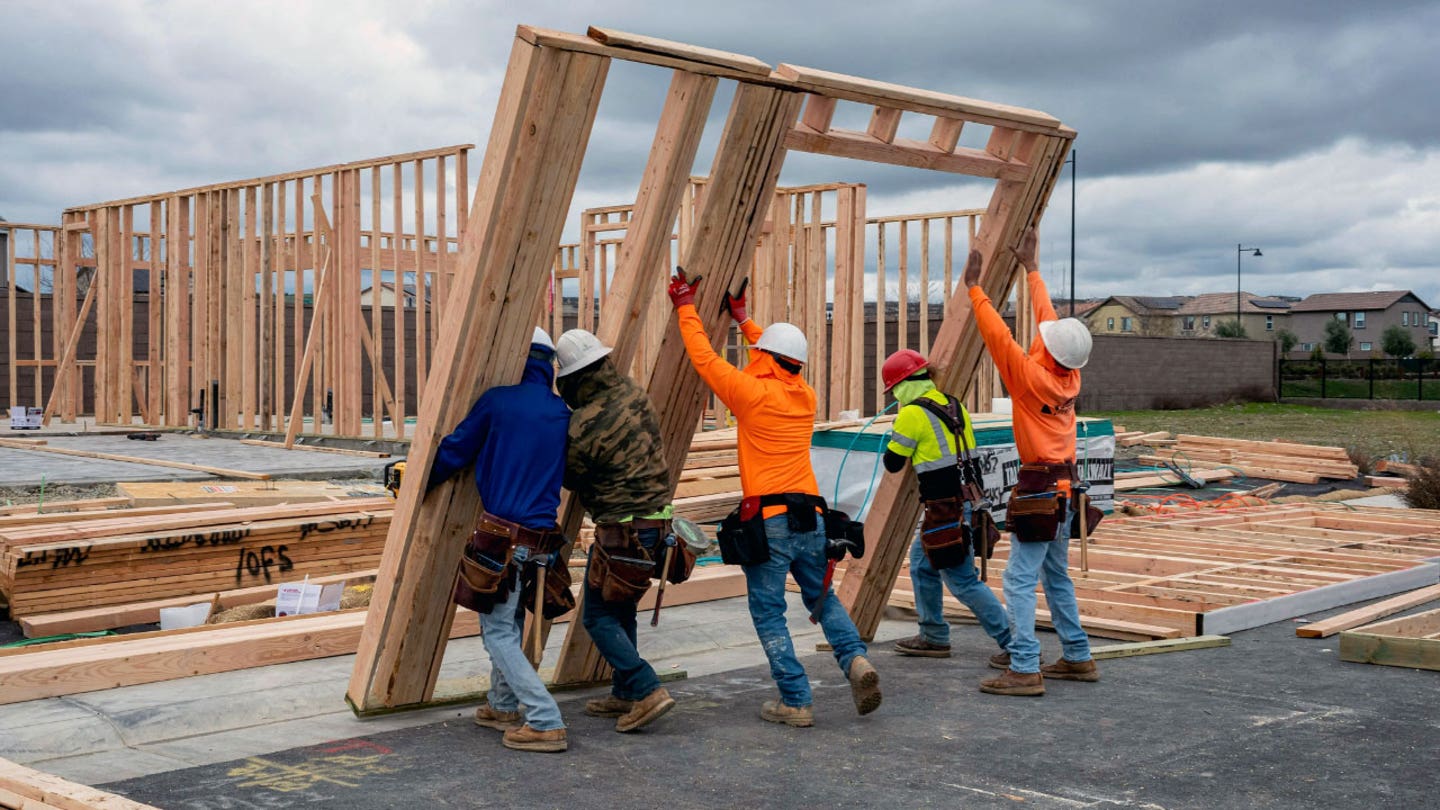 Construction workers lifting wooden beams on a new home build, illustrating America's 250,000-worker monthly construction labor shortage